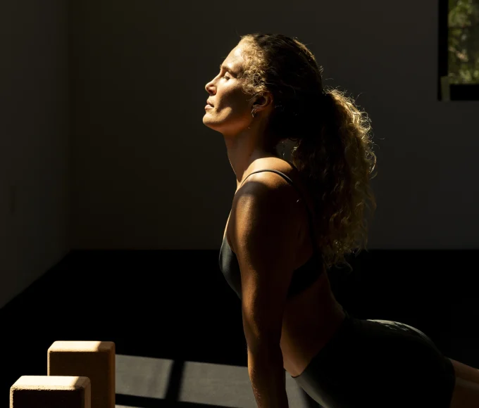 Woman stretching in upward-facing dog during a sunlit morning fitness session at The Ranch Malibu.