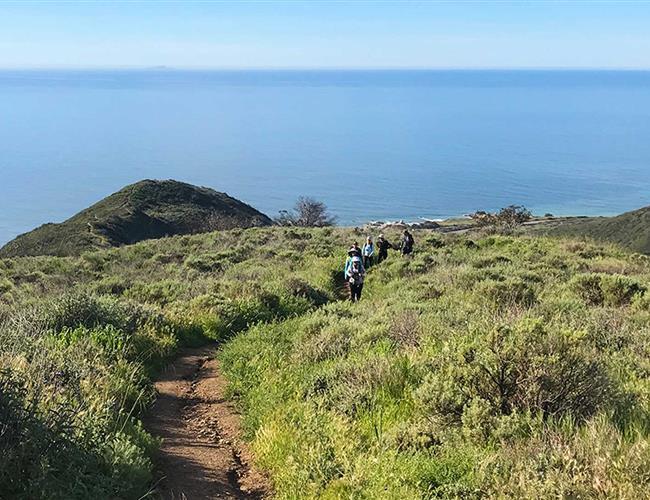 group hiking with ocean in the background