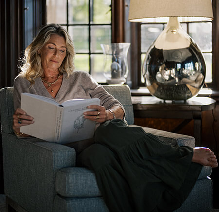 Woman reading a book in an armchair