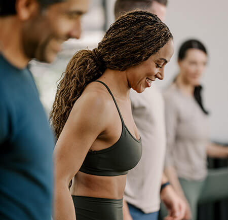 Woman smiling in workout wear between sets