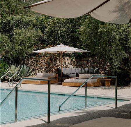 Pool on a sunny day with shade umbrellas and lounge chairs 